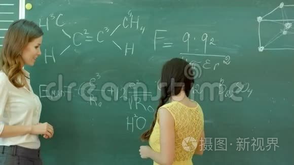学生在黑板上书写化学符号.