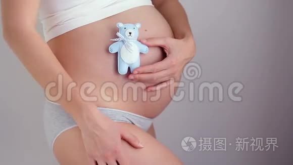 怀孕女孩抱着小熊玩具蓝色