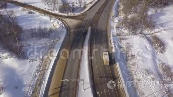 汽车和货运卡车从上面的飞行无人机在冬季公路上行驶。 雪道上的空中观景车交通