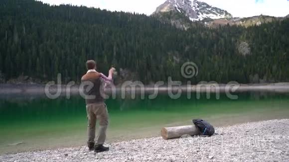 年轻人在风景优美的湖岸上旋转视频