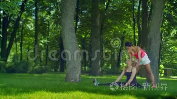 两个女人在户外草地上做伸展运动
