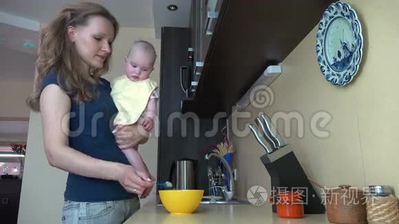 妈妈抱着小女儿，在厨房里用勺子喂。 4K