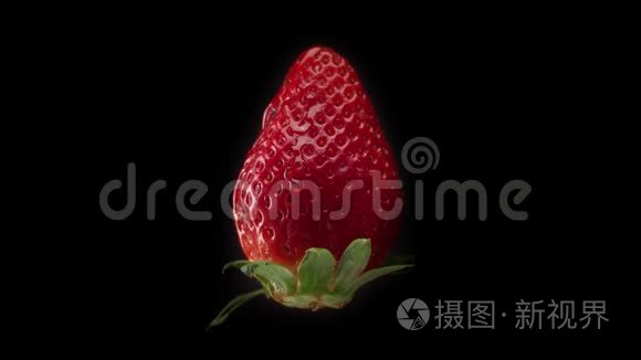 黑色背景下的新鲜草莓和透明滴在上面