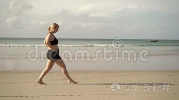 年轻的金发女人在海滩上做运动