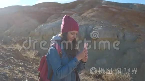 女徒步旅行者在山顶用手机拍照视频