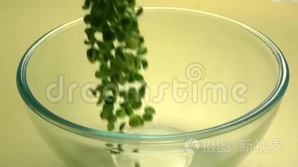 把干的青豆倒入玻璃碗里。 超级慢动作视频