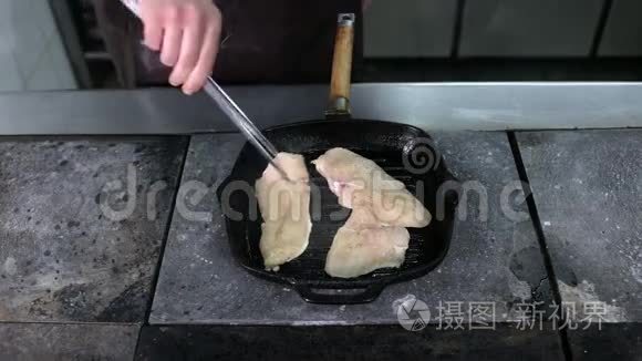 在烤锅上煎两片鸡片视频
