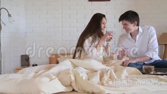 一对夫妇在阁楼房间的床上喝茶视频