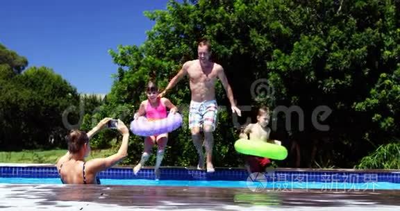 快乐的一家人在游泳池里跳视频