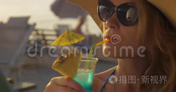 戴帽子和太阳镜的女人喝鸡尾酒视频