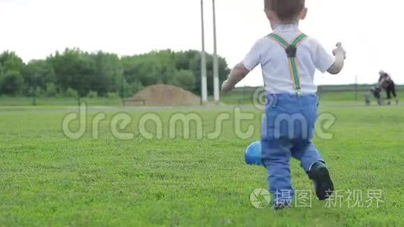 小男孩在草地上玩球