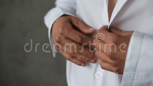 男人扣着一件白色衬衫