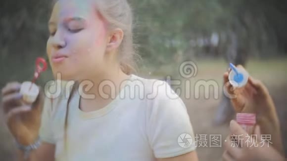 两个女孩弄脏了干燥的颜色霍利笑和吹泡泡