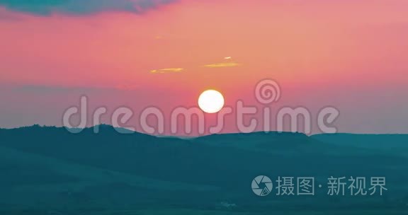 夕阳的背景下，夕阳落在紫罗兰色的云后，时光流逝，温暖多彩的天空