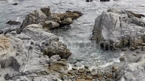 海滩上的岩石之间的波浪起伏视频