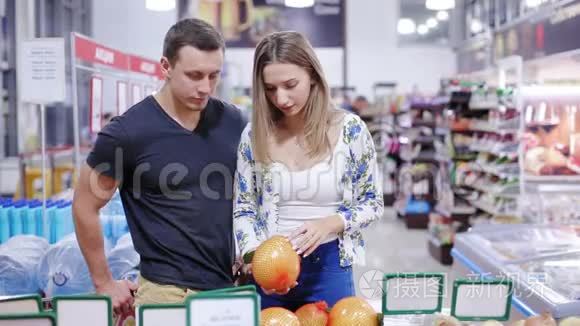 年轻夫妇在超市里摘水果视频