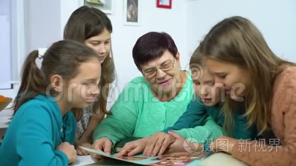 祖母向四个孙女展示旧相册视频