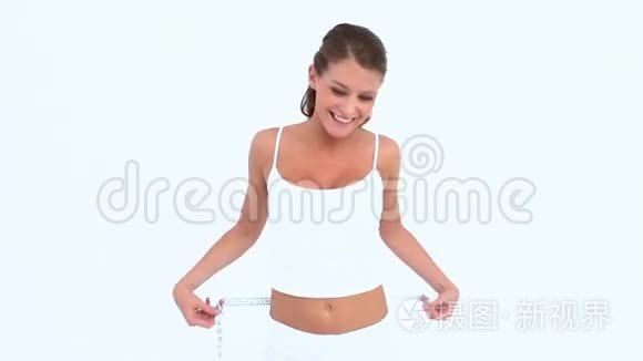 微笑的女人用带子测量她的腰视频
