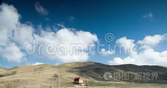 丘陵山谷中房子上方多云的天空视频