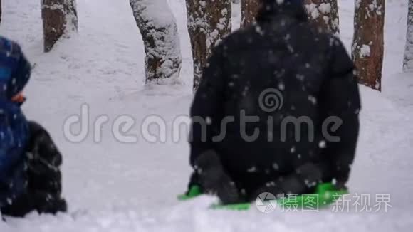 在松林的雪山上，孩子们滑下。 慢动作