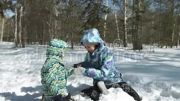 年轻的母亲帮助她的儿子从雪中解脱