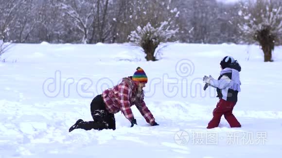 妈妈和小儿子在雪地里玩得很开心。 他们笑着掉进雪里。