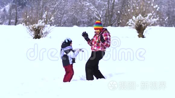 妈妈和小儿子在雪地里玩得很开心。 他们笑着掉进雪里。