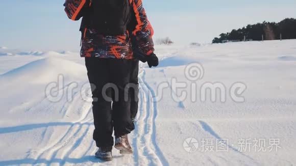 团队合作。 男游客摄影师冬天乘三脚架爬山顶山顶山顶群去下雪