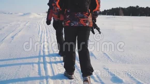 团队合作。 男游客摄影师冬天乘三脚架爬山顶山顶山顶群去下雪