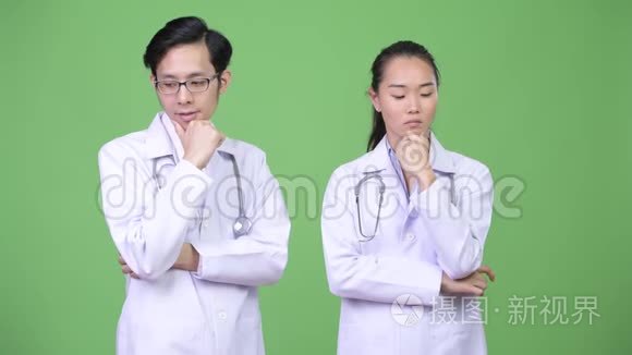 年轻的亚洲夫妇医生在一起思考视频