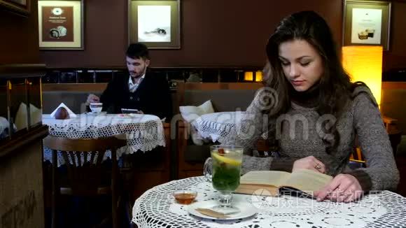 男孩和女孩坐在漂亮的咖啡馆里。 他