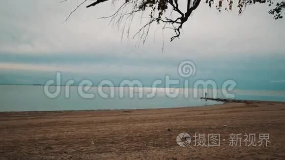 一个孤独的人沿着海滩散步