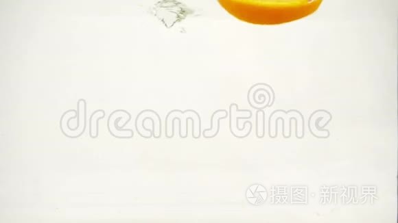 橙色切片落入水中，溅出气泡，慢动作特写