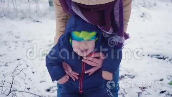 开朗一岁的男孩和母亲在冬天的森林里。
