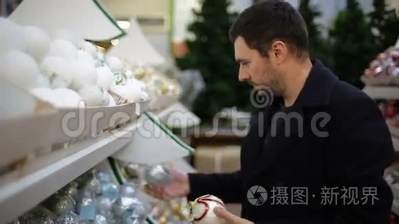 男人在商店里挑选圣诞装饰品视频