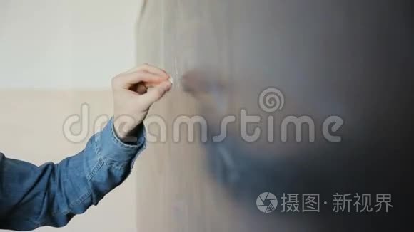 男科学家在黑板上书写高中数学和科学公式的手