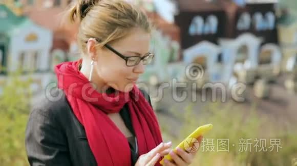 戴眼镜的美女在智能手机上打字视频