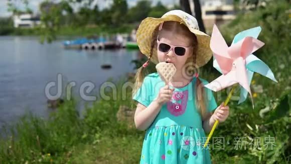 小可爱的女孩在海边吃着心形的冰淇淋