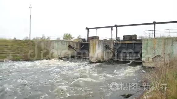 一股肮脏的褐色浑水流过大坝。