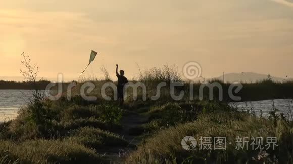 日落时放风筝的男孩慢动作剪影视频