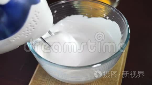 用电动搅拌器搅拌奶油。 在玻璃碗中加入蛋黄