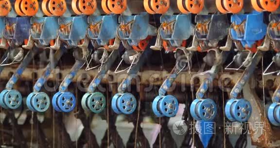 一台纺纱机在运行中收集卷筒机中的丝线。