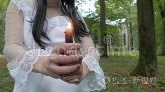 女孩看着燃烧的蜡烛，教堂在一个