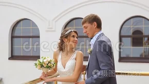 漂亮的年轻夫妇站在阳台上