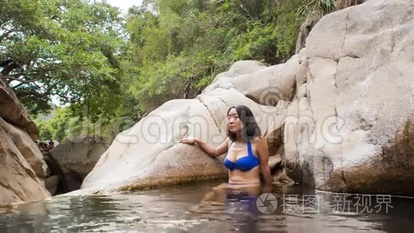 女孩坐在山涧造就的小湖里洗澡视频