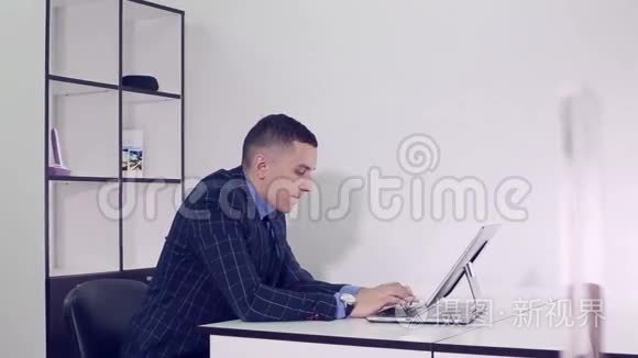 商人用电脑在桌子旁的办公室工作。