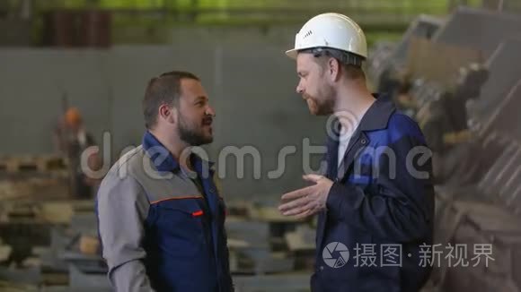 两位工程师讨论了重工业工厂的建设阶段。 焊工