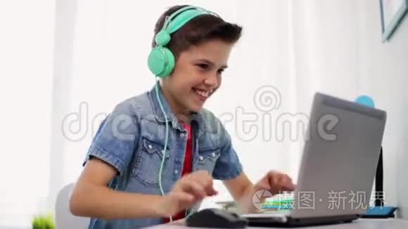 戴着耳机的男孩玩手提电脑游戏视频