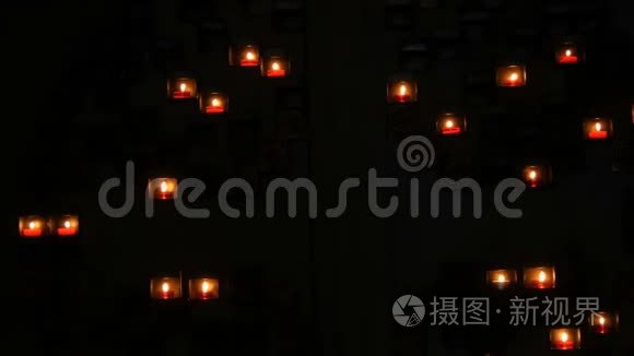 在天主教教堂的黑暗中，在一个特殊的壁龛里燃烧着美丽的红色圆形祈祷蜡烛。
