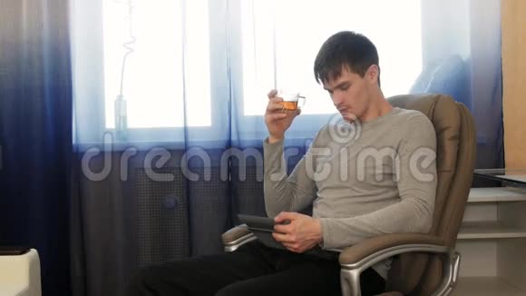 有平板电脑的人坐在椅子上喝茶mov4K视频素材